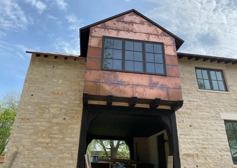Copper metal panel facade on a stone building for Skylight Installation in Woodcrest